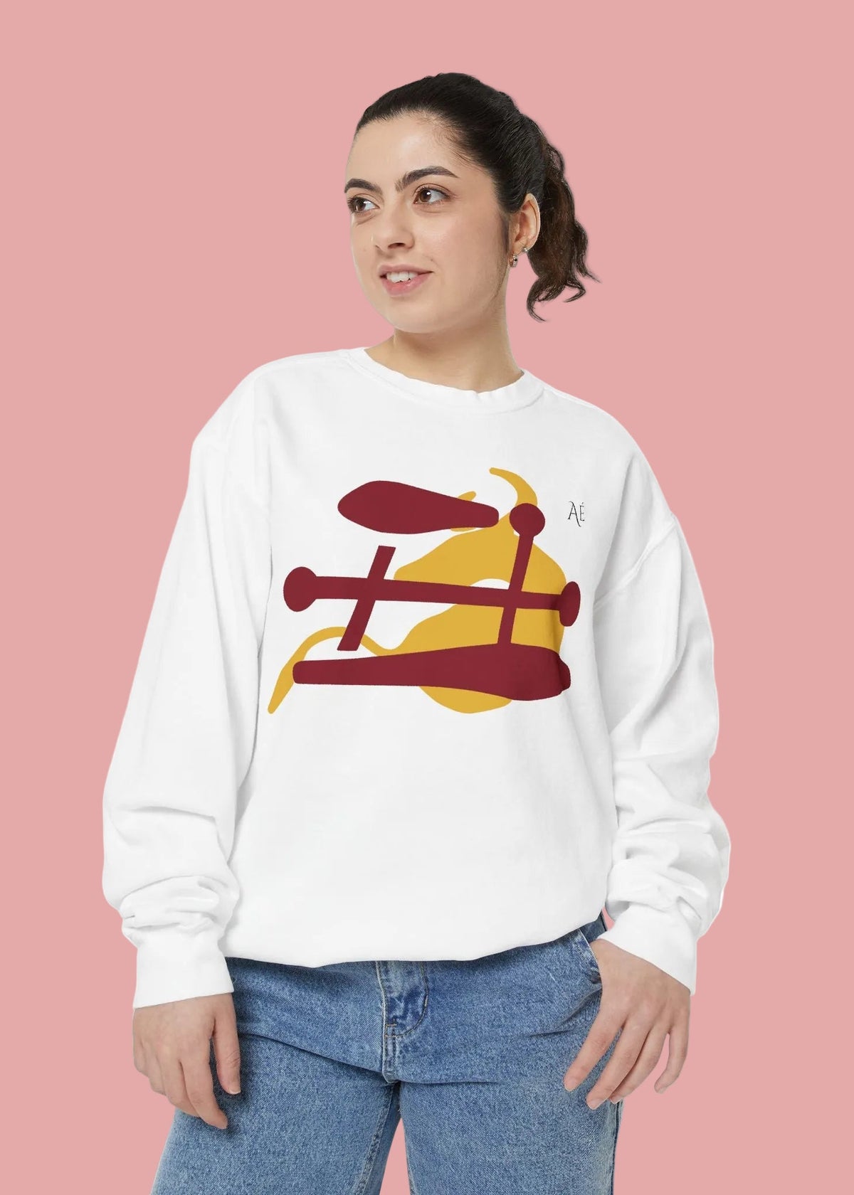 A woman wearing a white crewneck sweatshirt with a graphic of Ox japanese zodiac sign, paired with blue jeans, against a plain white background.
